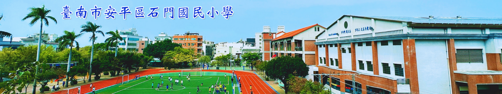 臺南市石門國小校園全景，畫面包含藍天下的教學大樓、紅色的塑膠跑道、翠綠的草地足球場，以及校門口的棕櫚樹，呈現生機蓬勃的校園氣象。